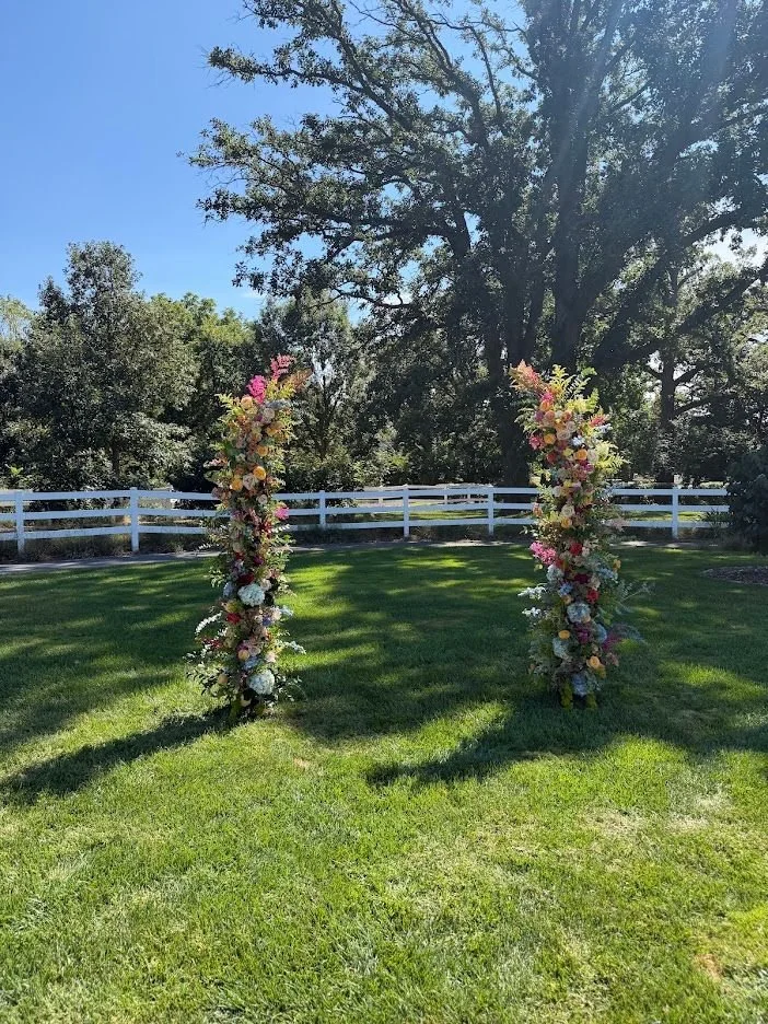 Two colorful floral columns standing on the lawn at Danada House for Max and Allie’s ceremony.