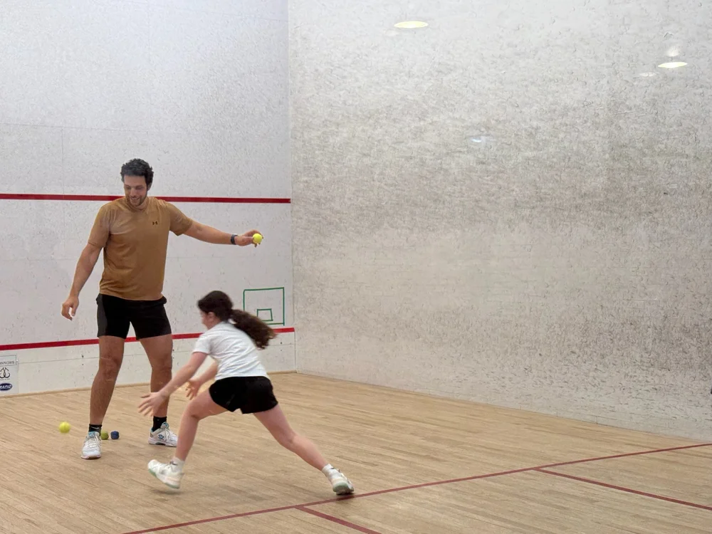 Omar Mosaad working with a junior player during a court exercise