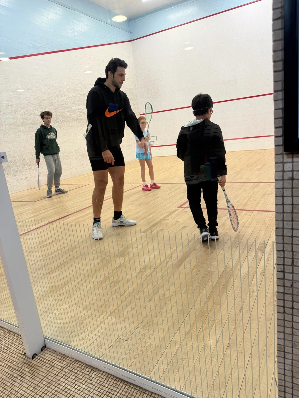 Omar Mosaad guiding junior players on a Monmouth squash court