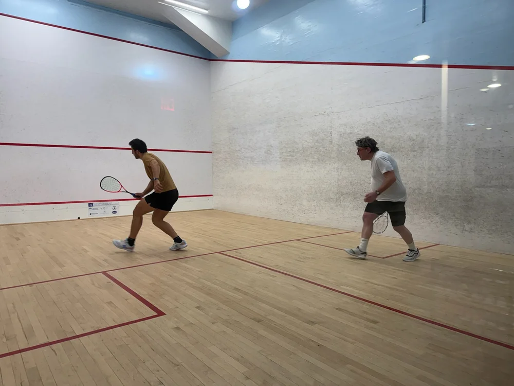 Omar Mosaad playing squash with an adult Monmouth member
