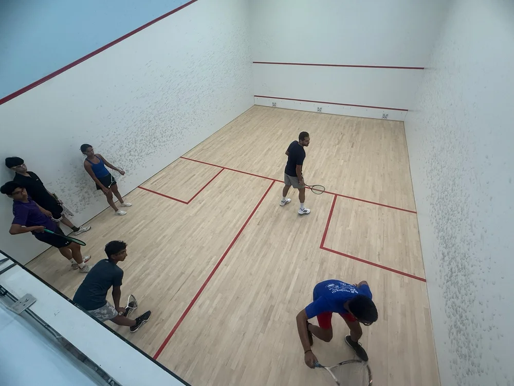 An elevated view of Karim Abdel Gawad on court with Monmouth junior players