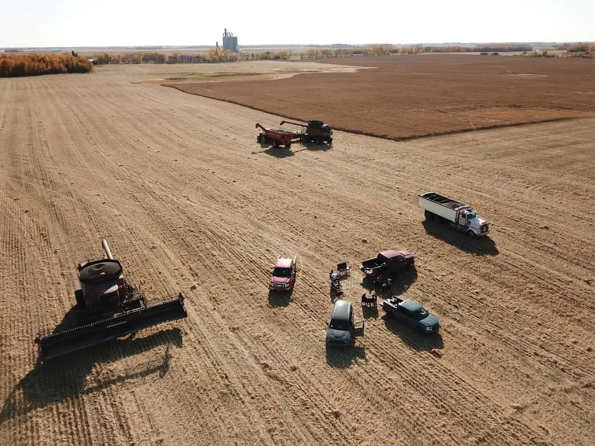 Aerial view of harvest equipment in a field in the County of Minburn