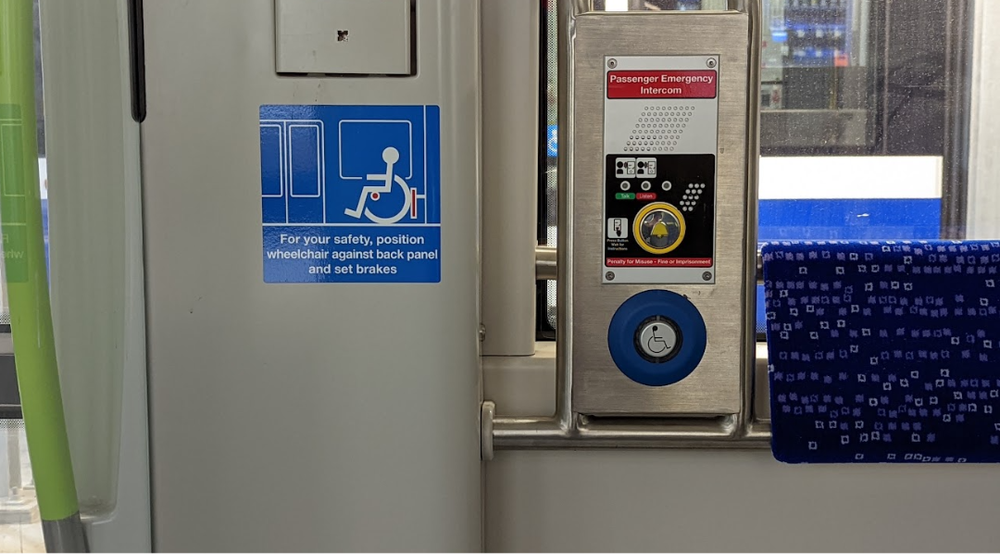 Wheelchair securement sign beside the passenger emergency intercom inside a Valley Line Southeast LRT vehicle