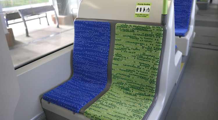 Blue and green upholstered seats inside a Valley Line Southeast LRT vehicle