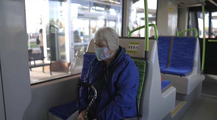 An older rider seated near the doors of the LRT vehicle