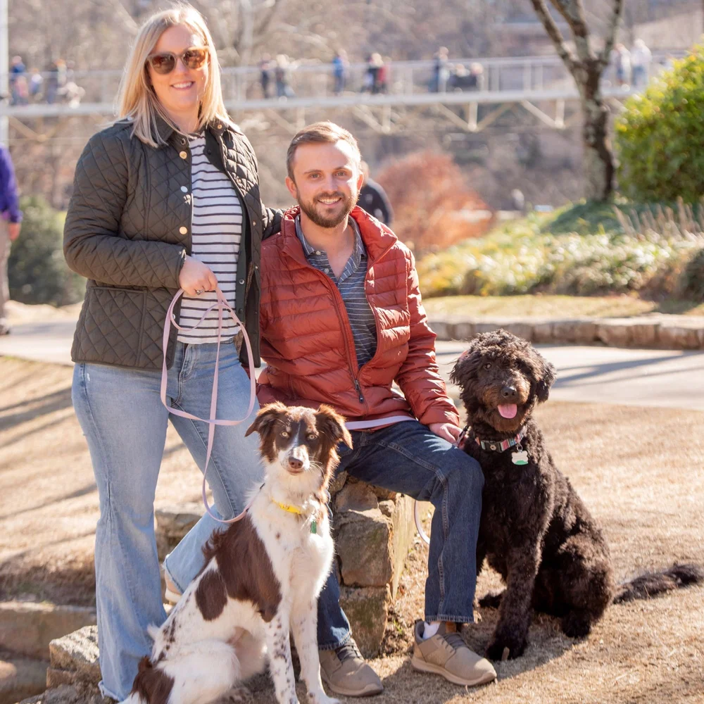 A couple relaxing downtown with their two calm dogs