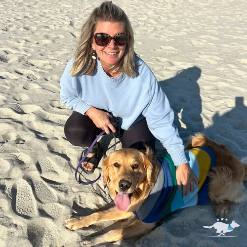 Owner relaxing on the beach with her dog