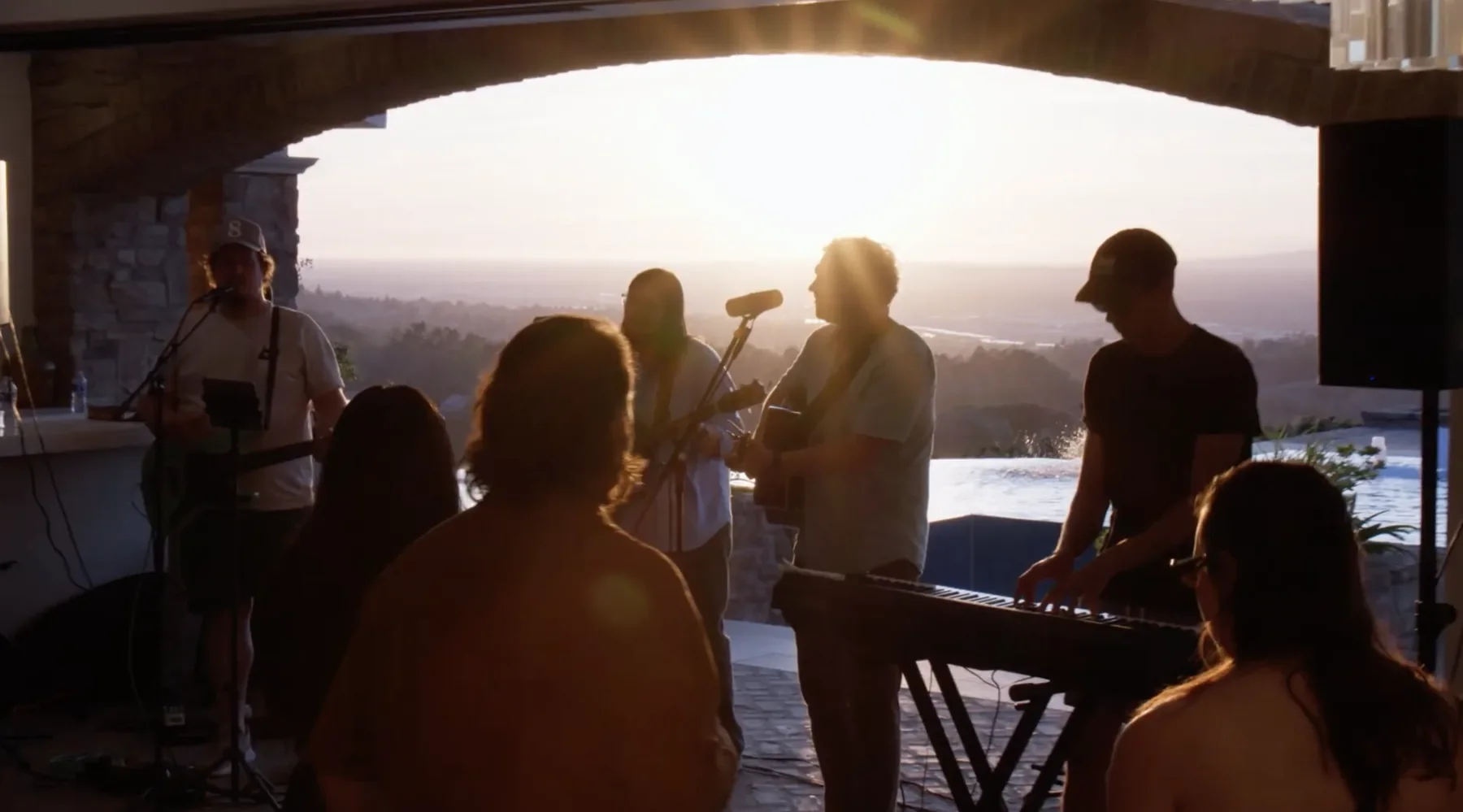 People worshiping together outdoors at sunset
