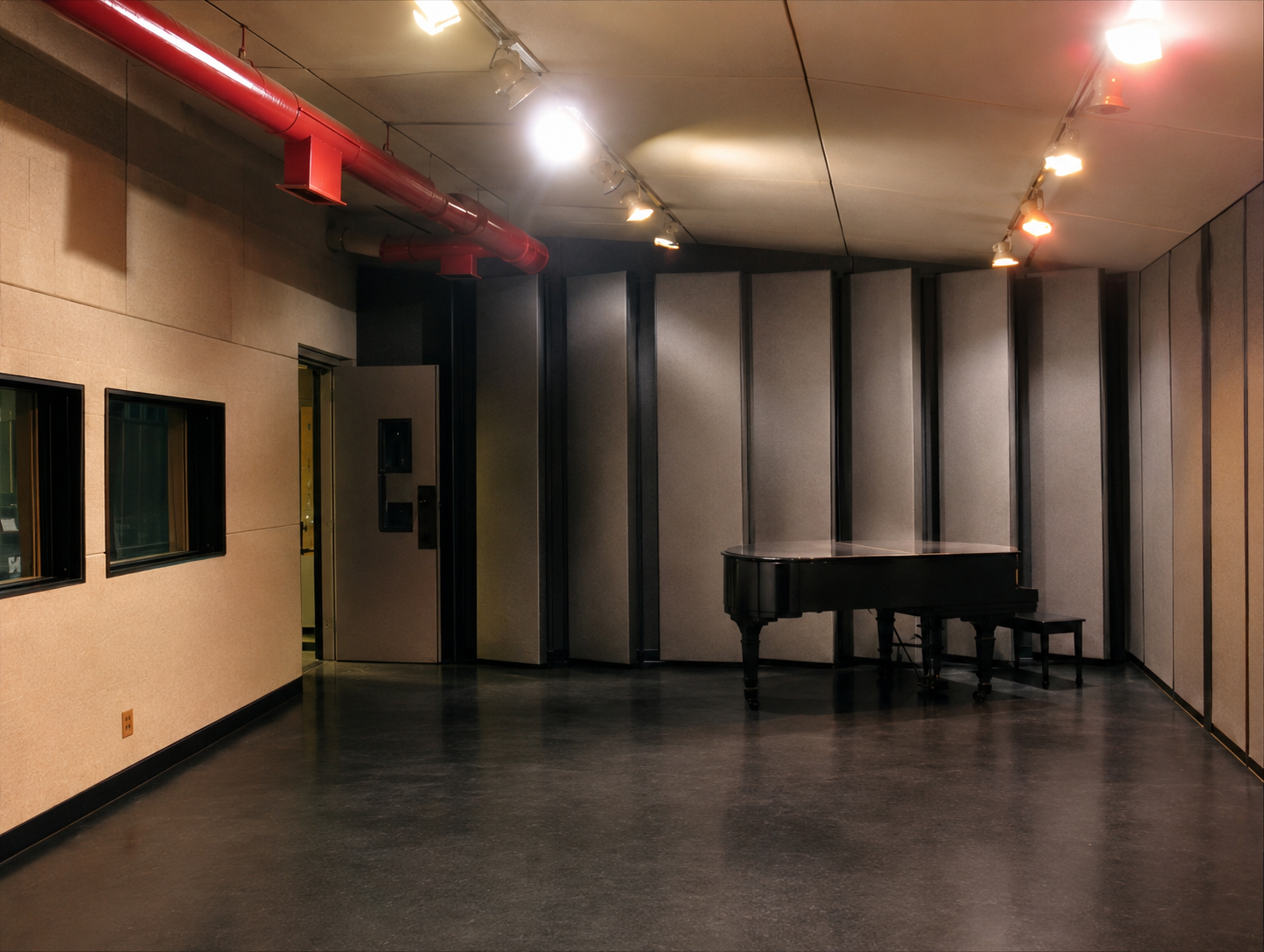 Sound City recording studio live room with piano, high ceiling and acoustic treatment.