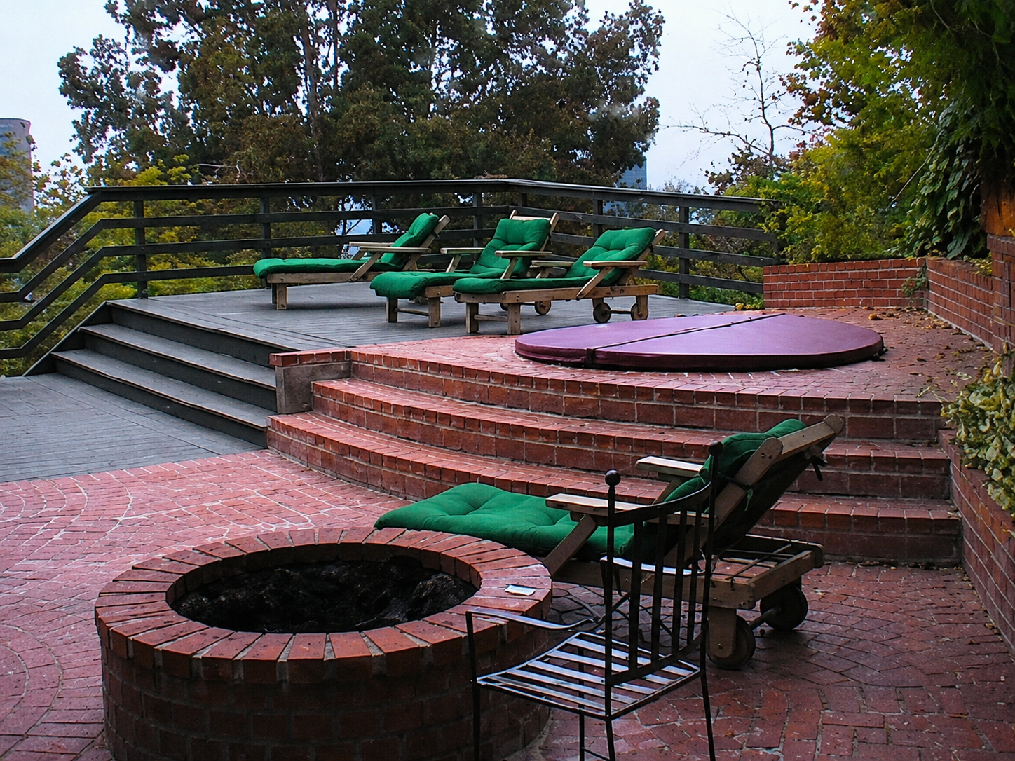 Hollywood Hills brick patio with spa, fire pit and hillside landscaping.