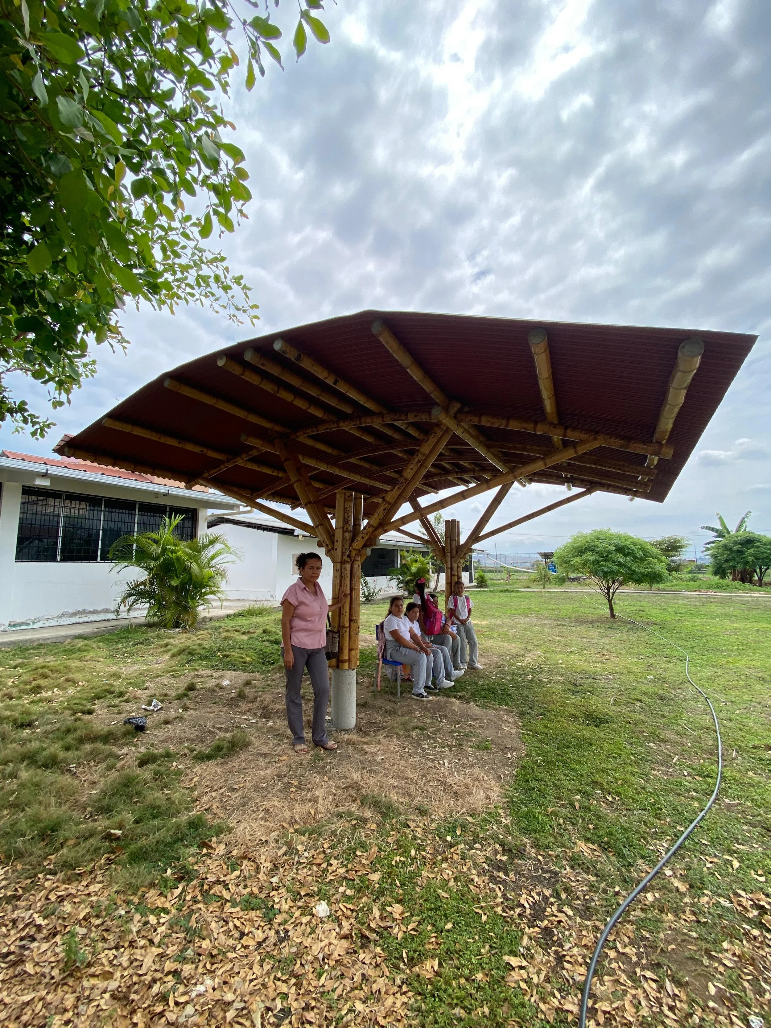 Builders learning bamboo construction methods through hands-on practice in coastal Ecuador.