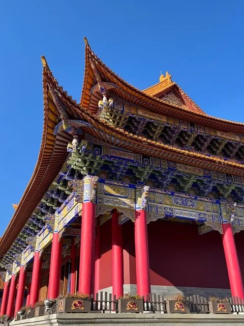 Red columns support richly painted brackets and upturned eaves at Chongsheng Temple.