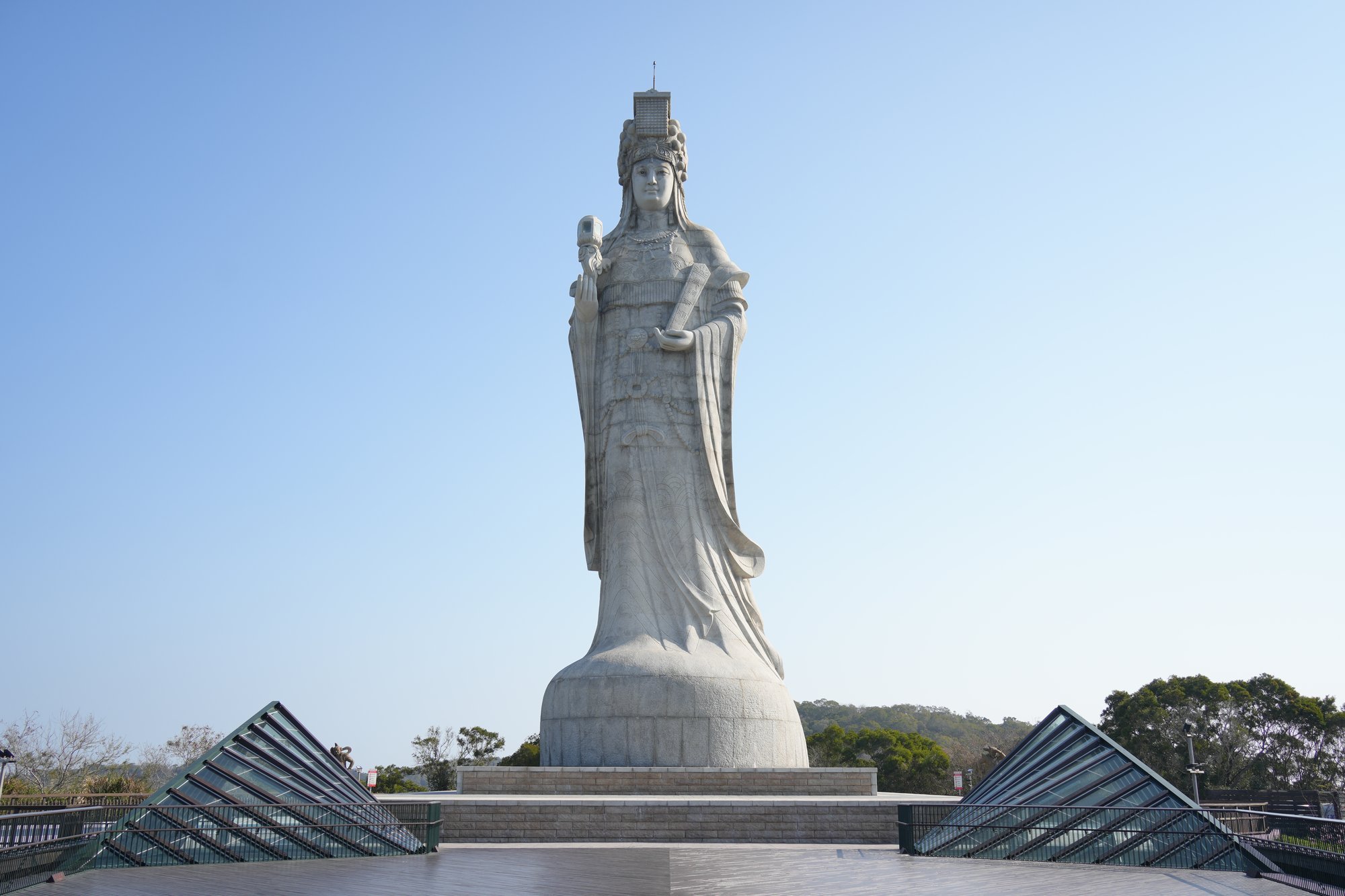 The granite Mazu statue rises above the angular roofs of its hilltop platform on Nangan.
