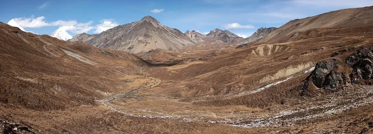A stream winds through the broad, treeless valley on the climb towards Bongteyla Pass.