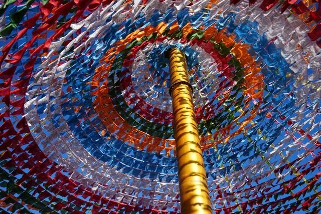 Concentric rows of prayer flags circle a golden central pole.