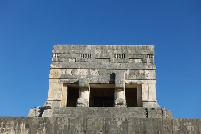 Serpent columns frame the upper Temple of the Jaguars at Chichén Itzá, beneath a frieze of jaguars and shields.