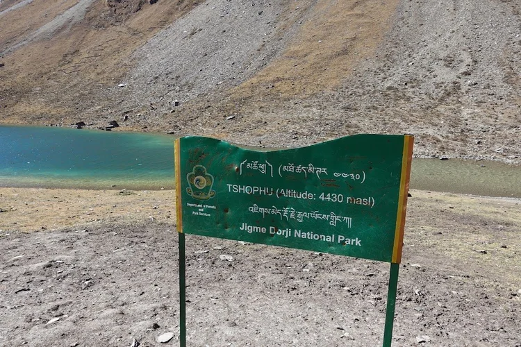 A park sign marks Tshophu at 4,430 metres, beside clear turquoise water.
