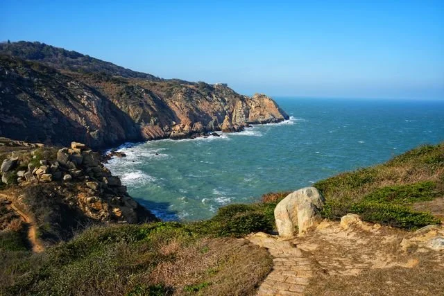White water traces the foot of rugged cliffs beside the coastal path.