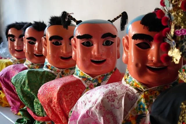 Painted deity puppets in patterned robes line up inside Niufengjing Wulinggong Temple.