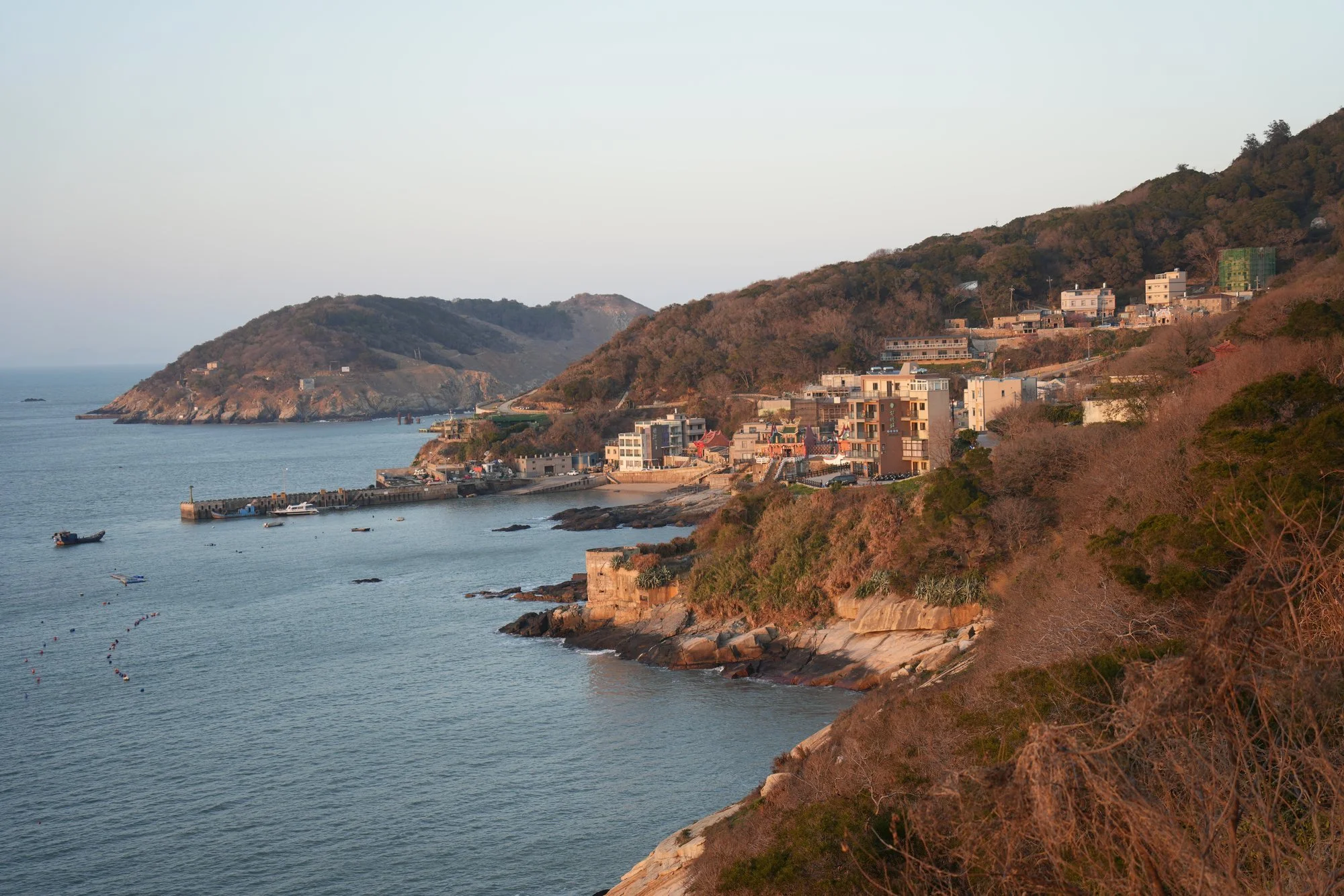 Late light warms a coastal village and its small harbour on Beigan.