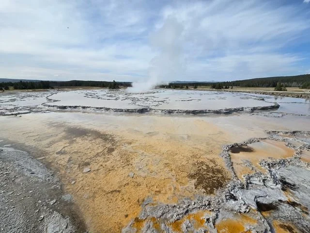 Shallow water traces the broad terraces around the steaming vent of Great Fountain Geyser.