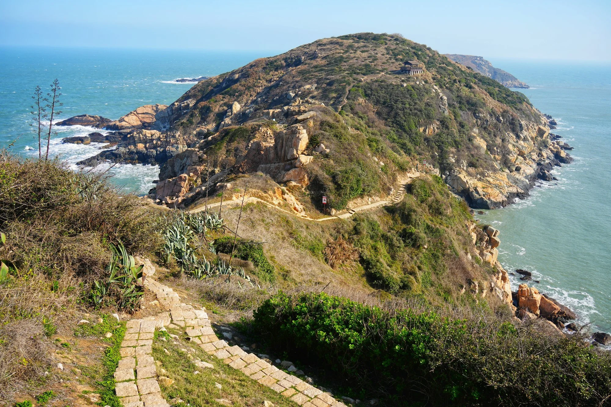 The Luoshan Nature Trail follows a rocky headland between two stretches of sea.