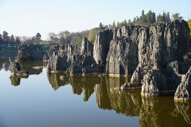 Jagged stone formations rise above still water and their reflections.