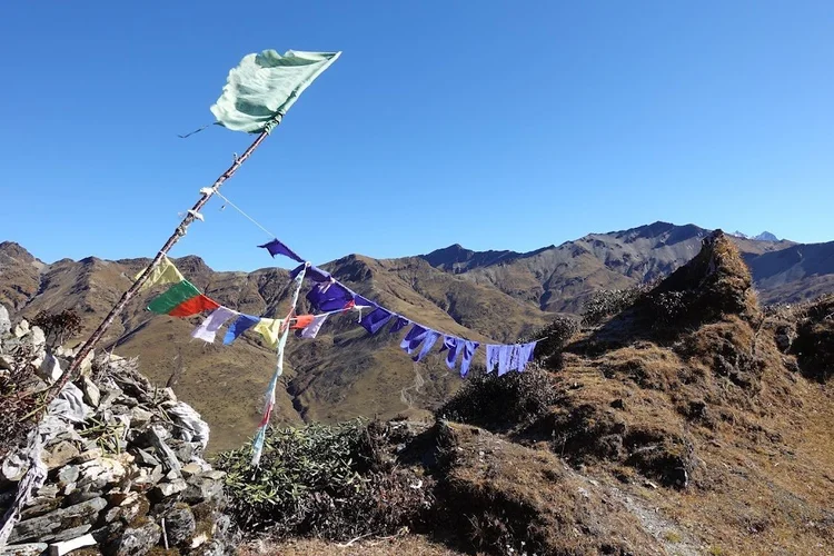 Prayer flags pull in the wind above the final day's ridge trail.