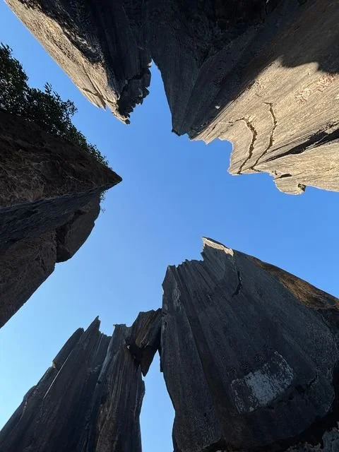 A patch of blue sky opens between the towering rock walls.