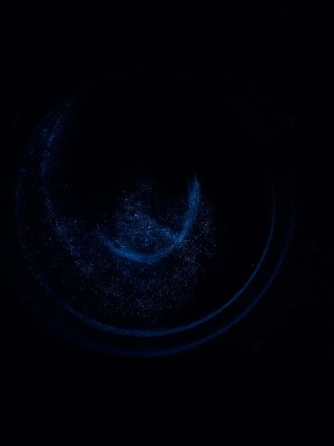 Blue points of light swirl in a demonstration container at the Blue Tears Ecological Museum.