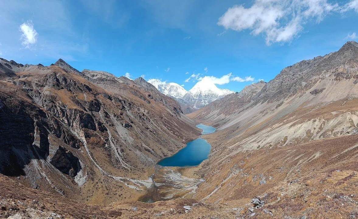 The two Tshopu lakes lie far below the trail, with Chomolhari and Jiujiudhaki at the head of the valley.