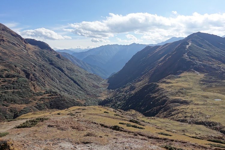 From above Tongphushong, the view follows a steep green valley towards layers of distant mountains.