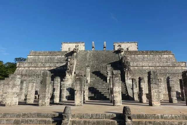 Carved columns cast long shadows below the broad stairway of the Temple of the Warriors at Chichén Itzá.