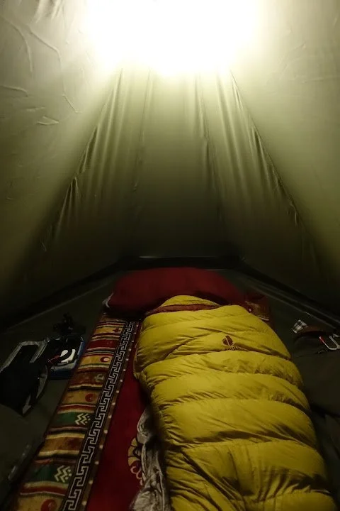 A sleeping bag, pillow and patterned mat make a small shelter for the cold mountain night.
