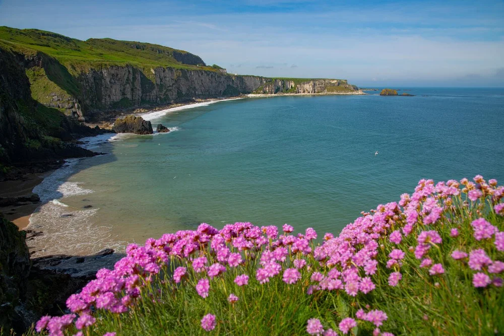 Sea cliffs falling away to open Atlantic water under a wide Irish sky