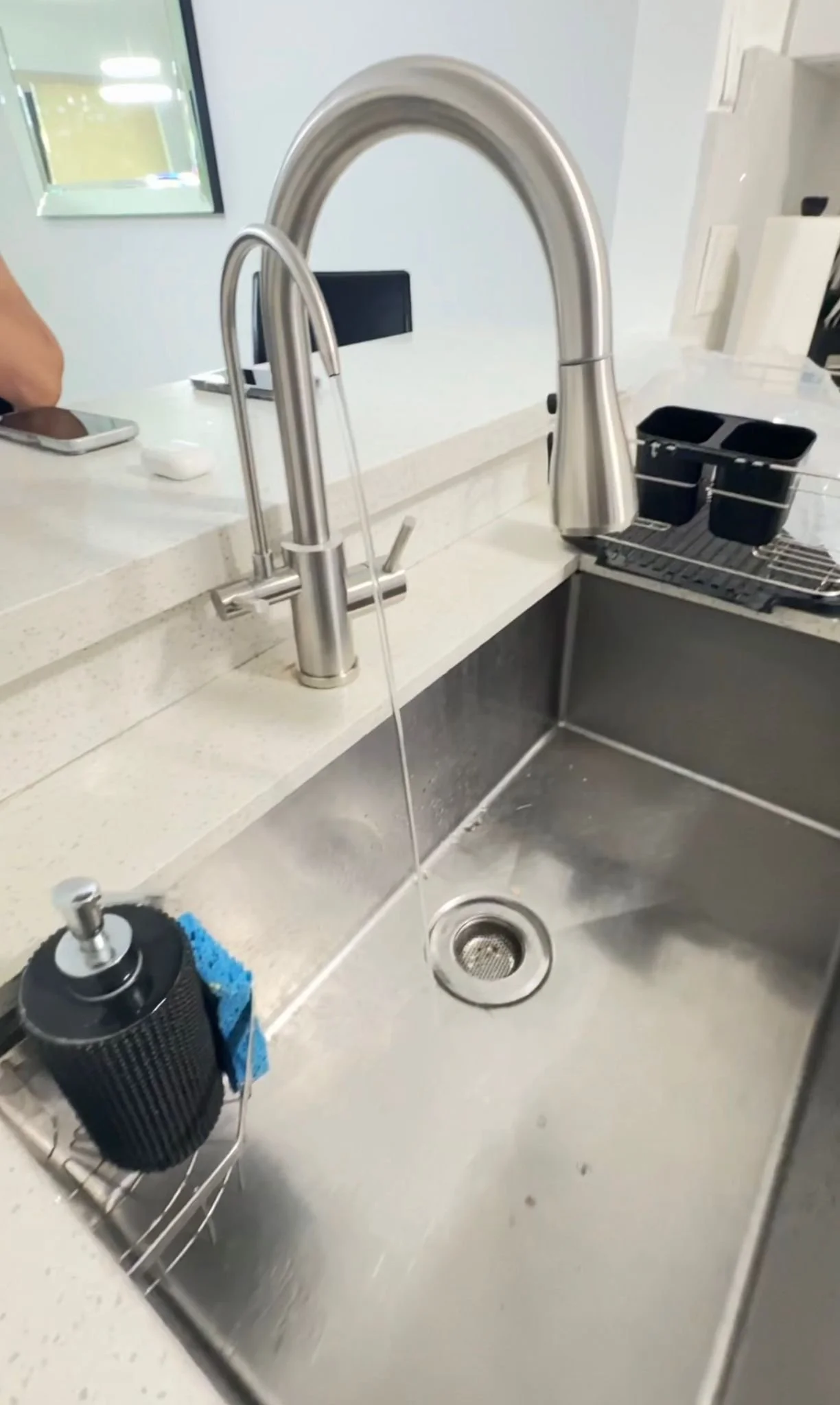 Combo faucet installed in kitchen, water running