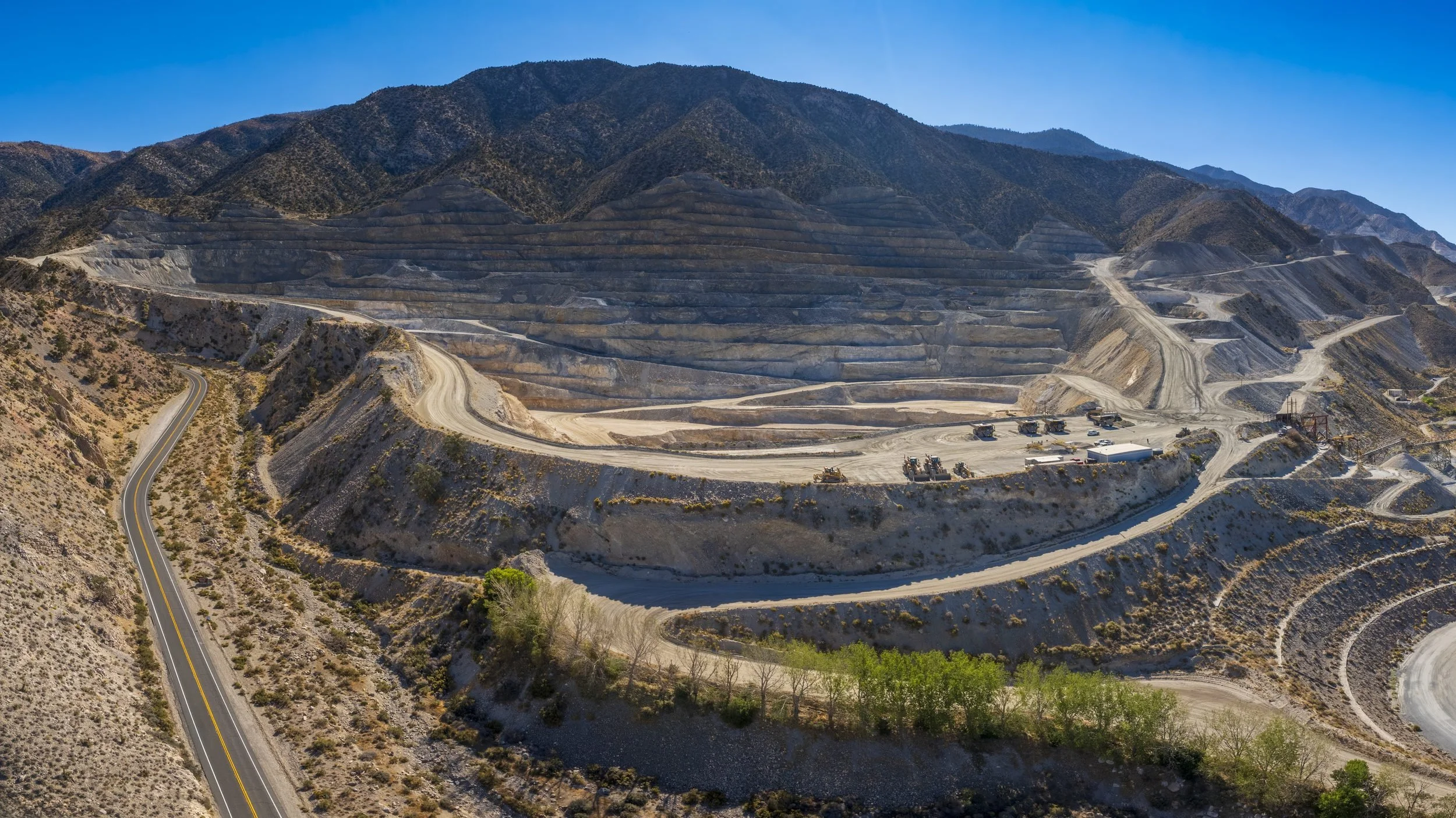 Drone aerial of a terraced cement quarry and processing plant in the desert