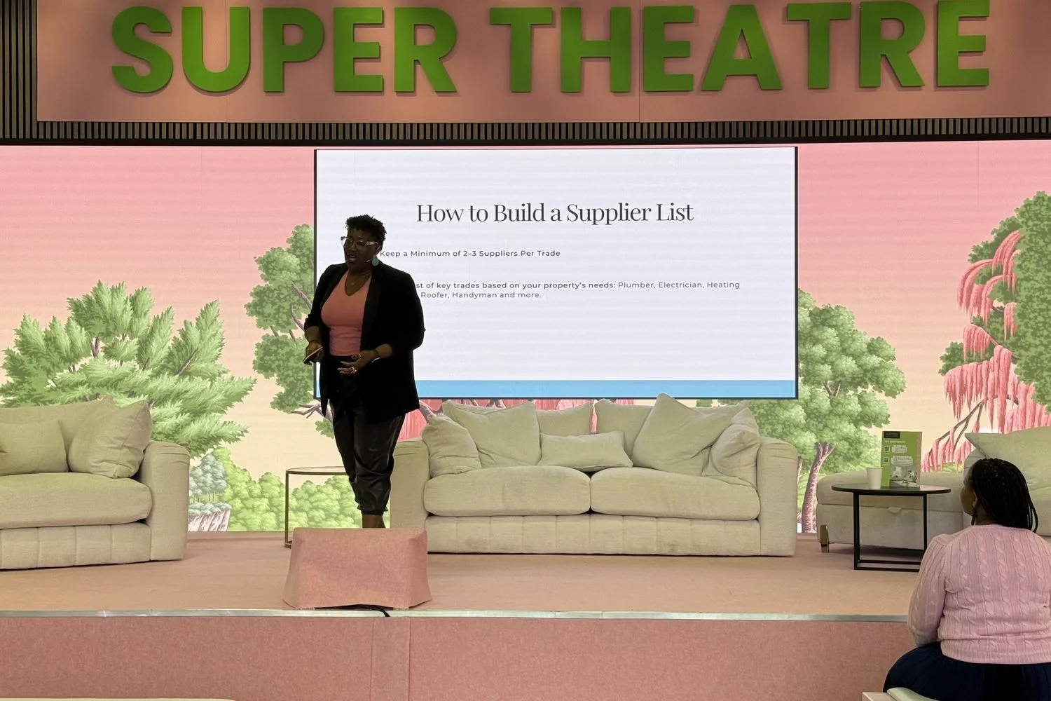 Timi Phillips speaking on stage to an audience