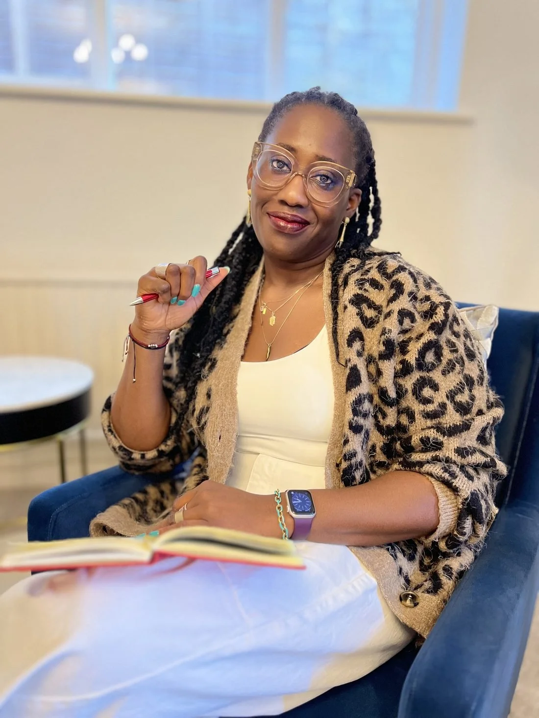 Timi Phillips seated with an open notebook and pen, thinking