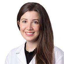 Dr. Sameha Abdulbaki, DMD, pediatric dentist at Kid-1 Pediatric Dentistry, smiling in a white coat