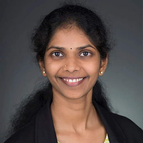 Dr. Sireesha Kodali, D.M.D., M.H.A., pediatric dentist at Kid-1 Pediatric Dentistry, smiling in a dark blazer