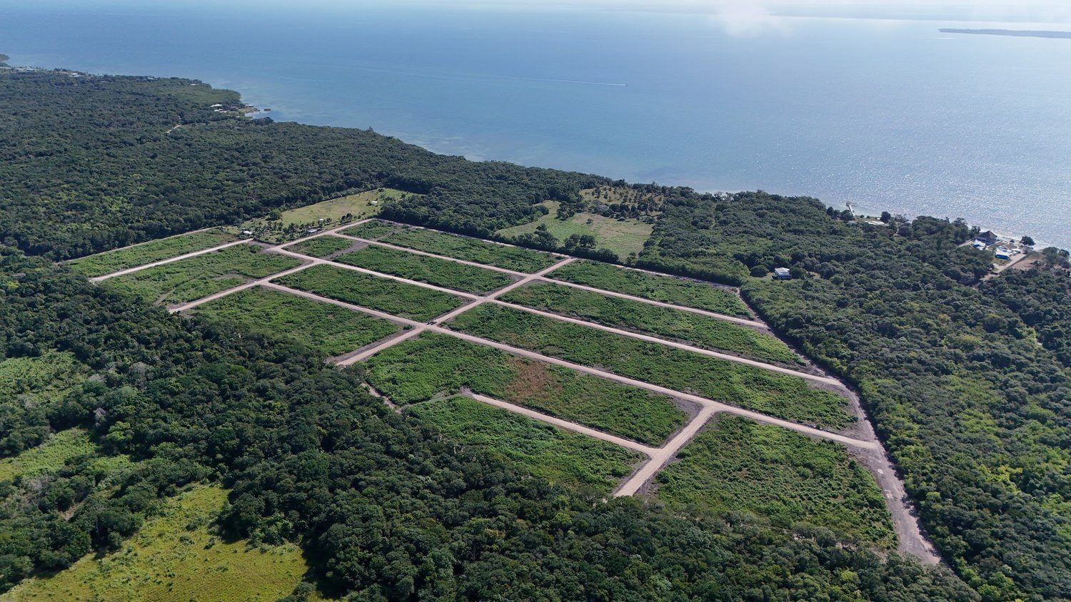 Aerial view of newly cut gravel roads dividing residential lots in a northern Belize subdivision