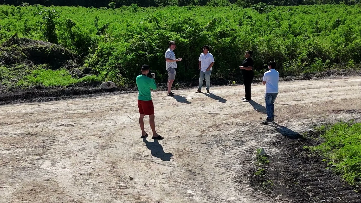 Prospective buyers walking along a road between surveyed lots at Coastal Vista