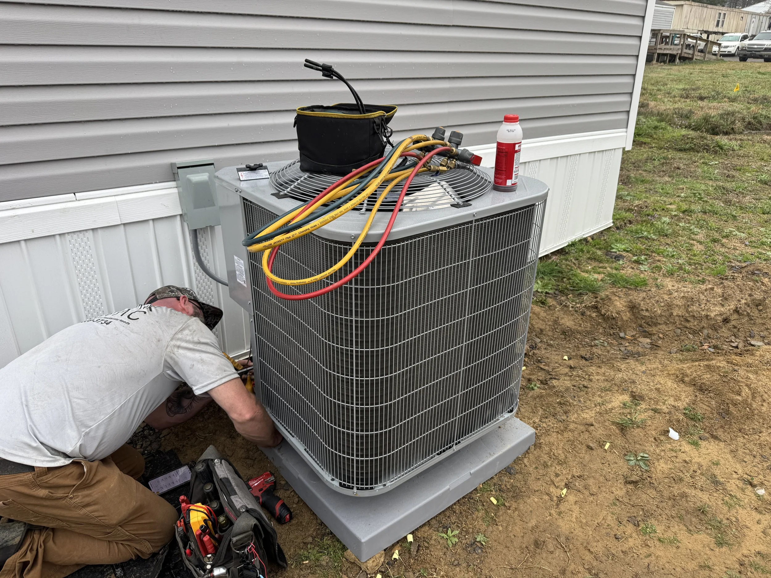 Clark HVAC technician performing AC service on a residential air conditioning unit