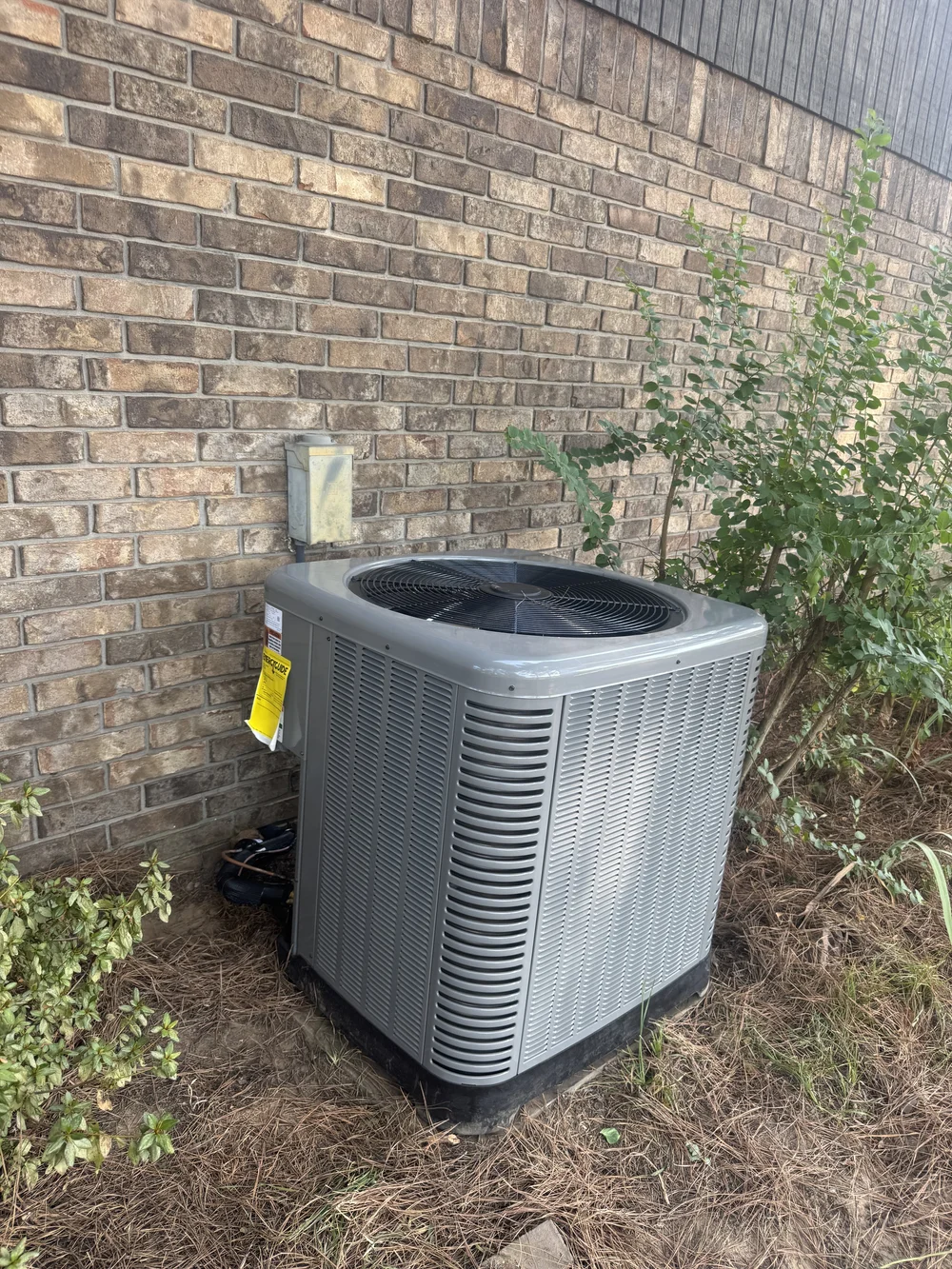 AC condenser beside a brick home on a Clark HVAC repair call in Spiro, OK
