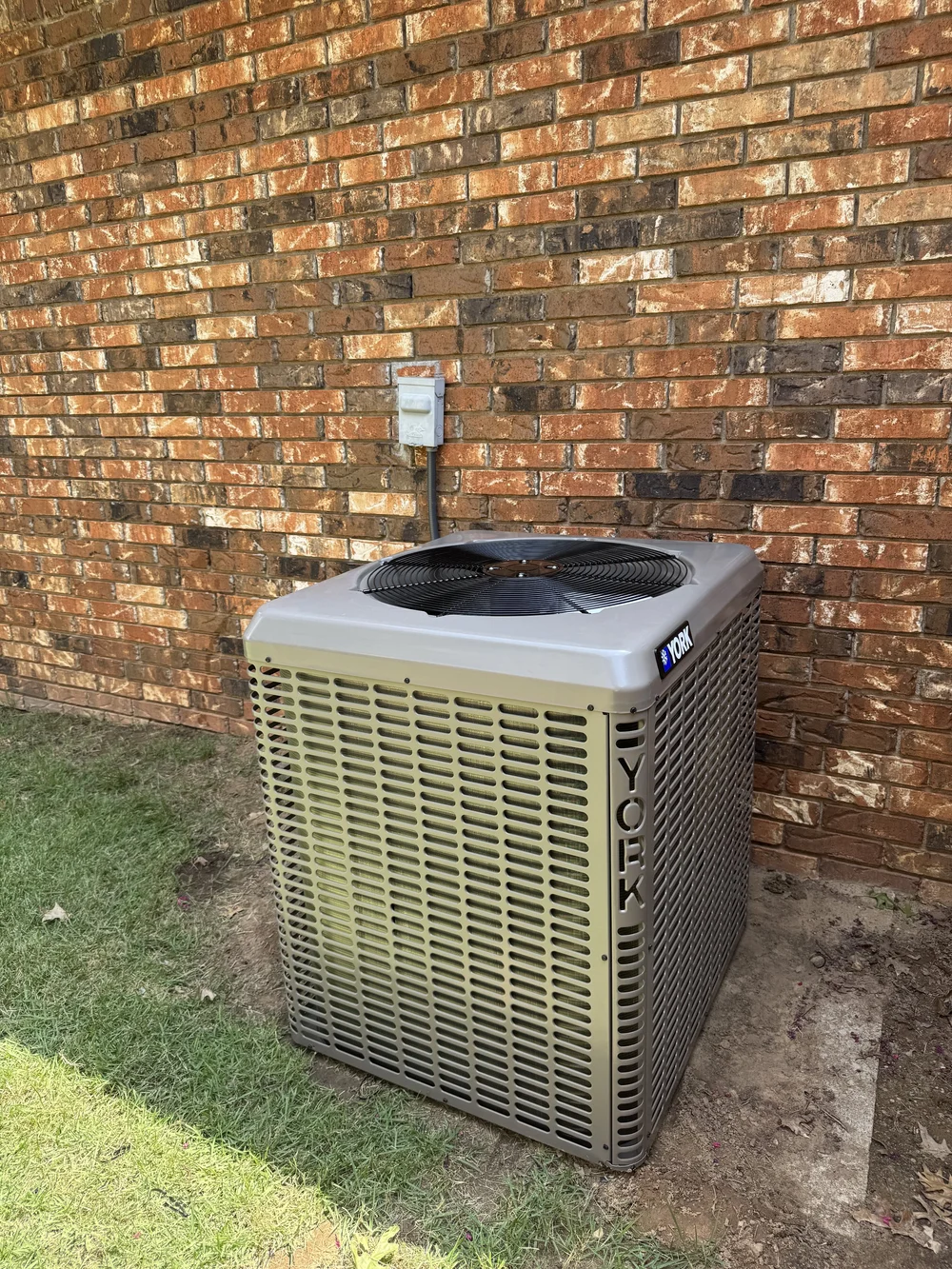 New York air conditioner condenser at a brick home in Fort Smith, AR, replaced by Clark HVAC