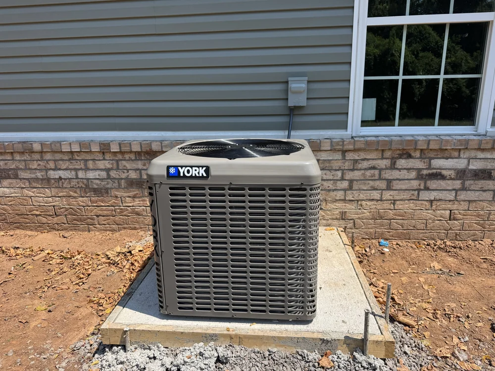 York AC condenser on a fresh pad at a new-construction home in Van Buren, AR, installed by Clark HVAC