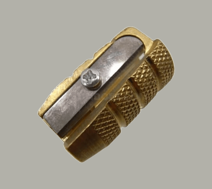 A small brass, bullet-shaped pencil sharpener
