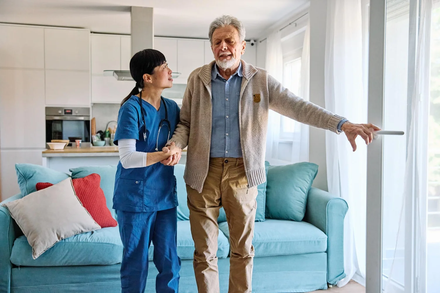 Caregiver helping an older man move safely through his home