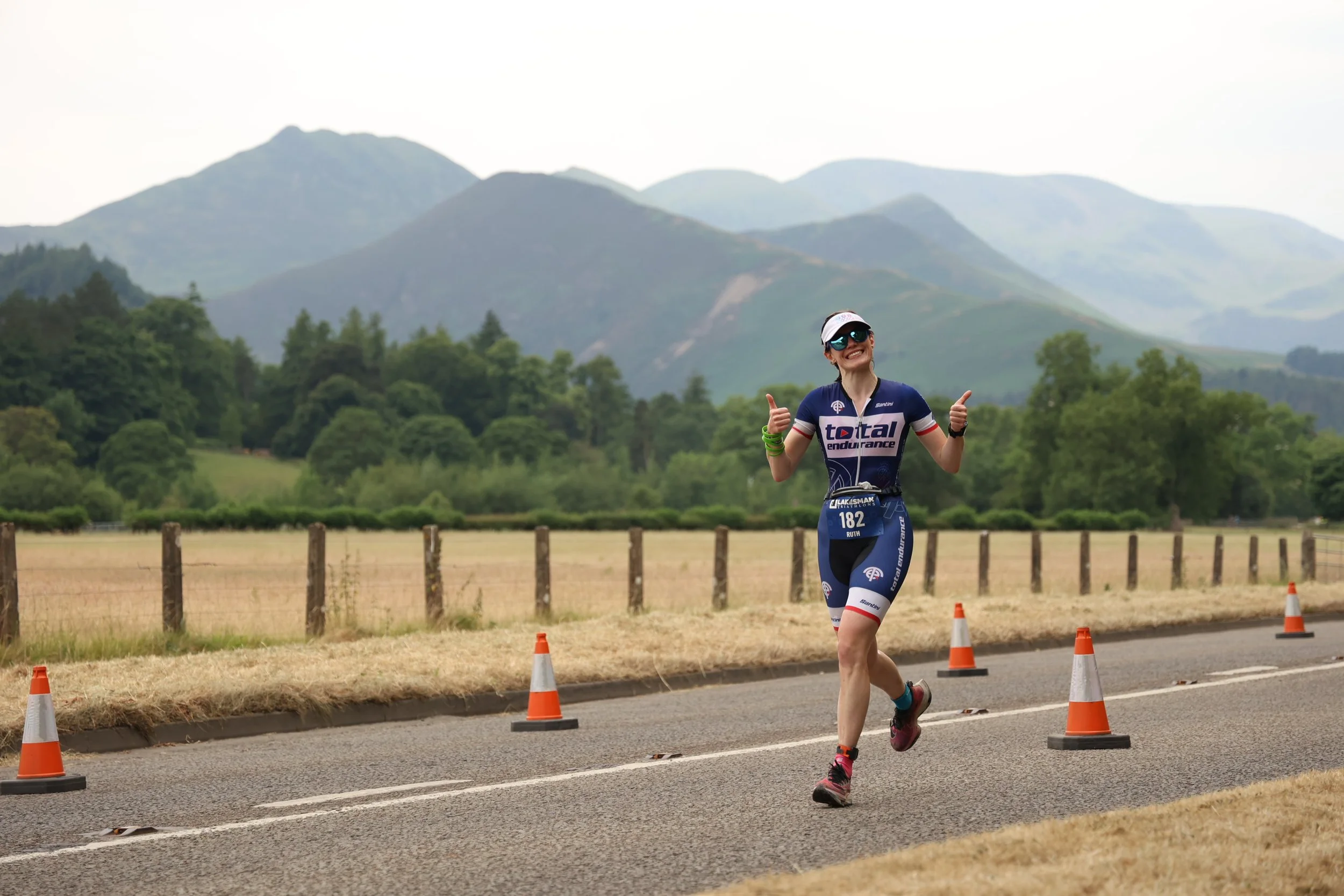 Ruth Hills, Total Endurance athlete, running the Lakesman Triathlon with the Lake District fells behind her